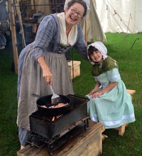 Load image into Gallery viewer, Karen &amp; grand-daughter cooking on brazier at livinghistory event
